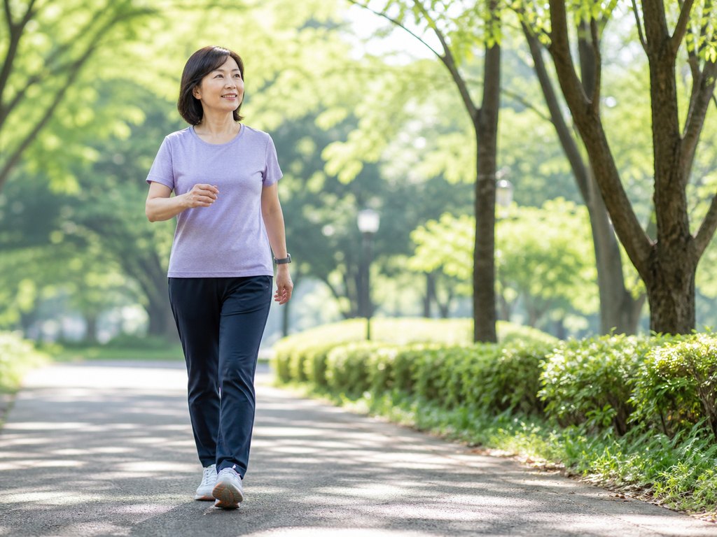 Woman walking outdoors on a sunny tree-lined path to illustrate Japanese interval walking for diabetes